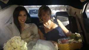 Bride seated in a car with the mother of the bride
