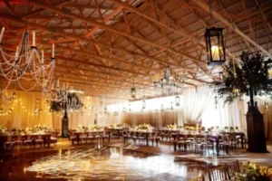 Rustic barn wedding reception with chandeliers and string lights