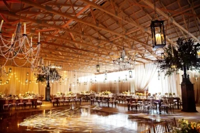 Rustic barn wedding reception with chandeliers and string lights