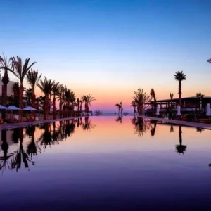 Chileno Bay Resort reflected in a pool at sunset