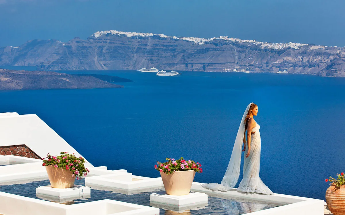 Bride overlooking the blue sea in Santorini