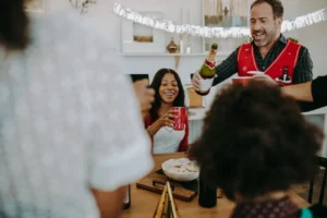 Holiday party host pouring champagne for guests