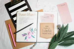 Wedding planning notebook and stationery arranged on a desk