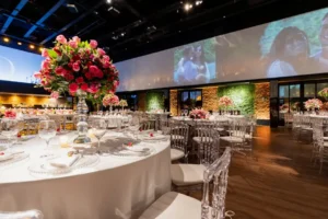 Luxury event reception with vivid floral centerpieces and large screens