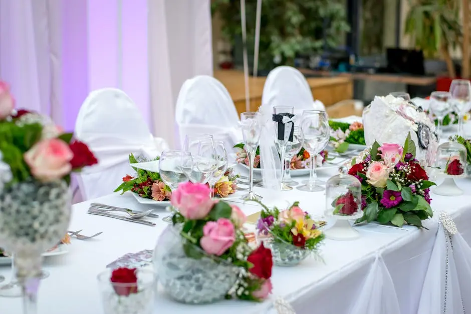 White wedding reception table with pink flowers and greenery