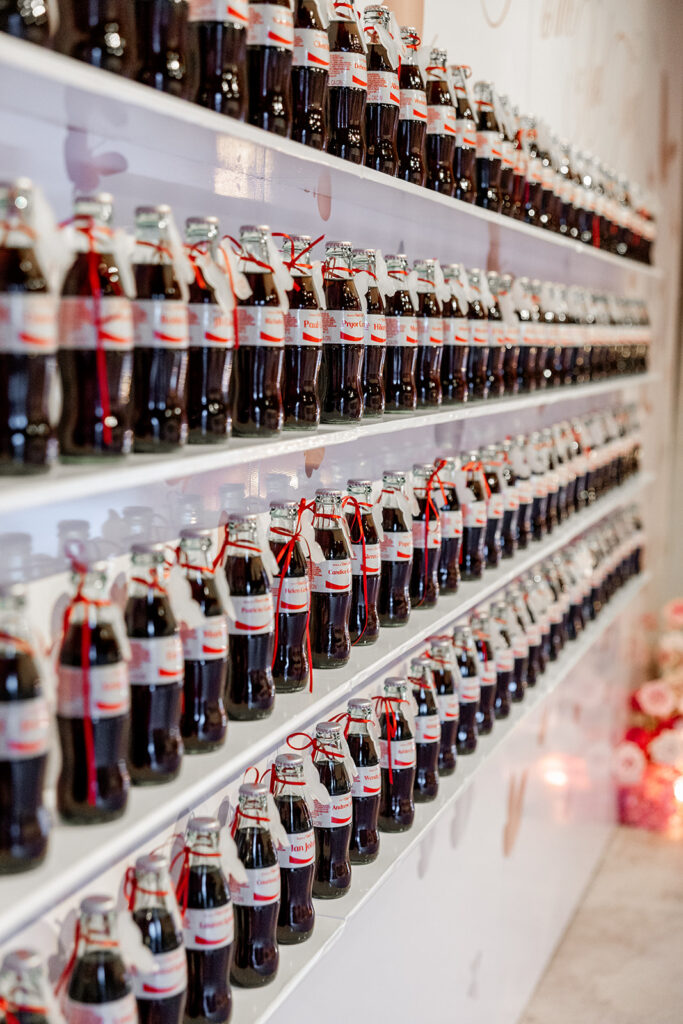Rows of bottled beverages displayed along a modern event wall