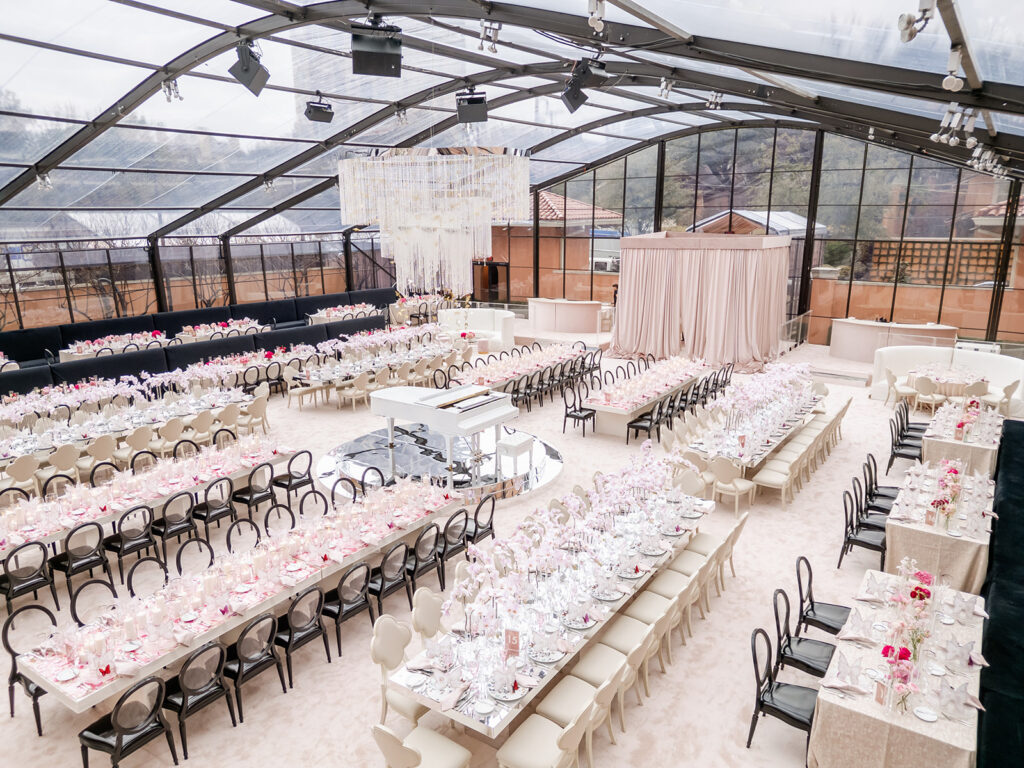 Elegant wedding reception setup with long dining tables, floral details, and coordinated place settings.