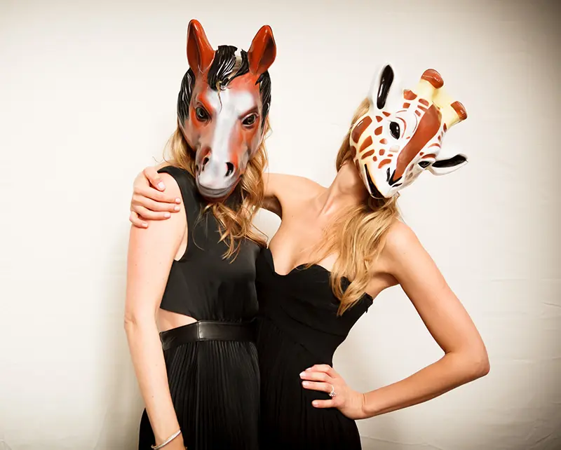 Two guests wearing horse masks during a playful private event entertainment moment.