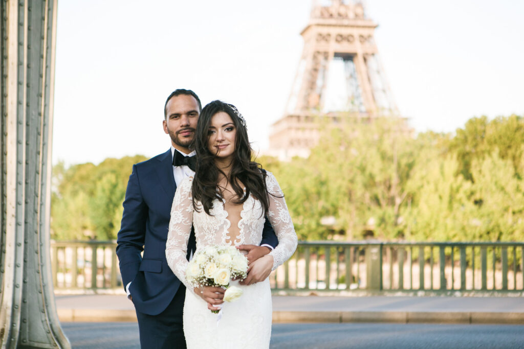 Bride and groom posing near the Eiffel Tower during a Paris destination wedding
