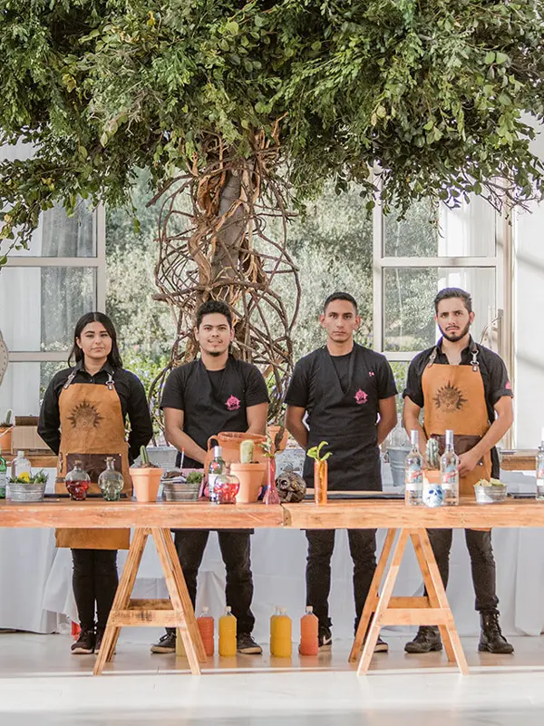 Event staff behind a custom bar setup at an elegant tented wedding reception.